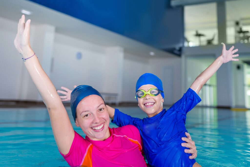 Swimming school. Cute little boy having fun with swimming instru